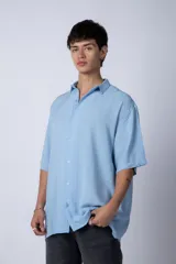Camisa de manga corta con cuello cubano, confeccionada en fibrana premium. Presenta un corte oversize y cierre frontal con botones al tono.