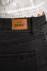 Jean de corte baggy con tiro medio, confeccionado en denim de color gris lavado. Presenta un diseño de pierna ancha con costuras horizontales a la altura de la rodilla y cierre frontal con botón y cremallera.