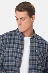 Camisa de viyela a cuadros tipo leñadora, con cuello abotonado, cierre frontal con botones y bolsillo en el pecho.