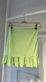Minifalda verde lima de lycra elastizada con volados en el ruedo.