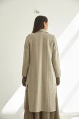 Tapado con cuello solapa y corte recto, color gris. Cierre frontal con botones ocultos, tajos laterales y bolsillos escondidos en corte lateral. Con forro. Tela 100% lana fina sin teñir, diseñada exclusivamente por Don Baez. Hecha 100% en Uruguay.