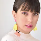 Aros colgantes con piezas geométricas de acrílico en colores rosa, celeste y amarillo.