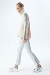 Pantalón jean plateado de tiro medio/alto con silueta levemente acampanada desde la rodilla y aberturas en los tobillos.