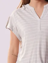 Remera gris a rayas horizontales blancas, con cuello a la base y escote en V. Manga corta con presilla y botón.