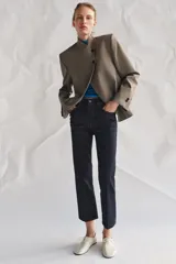 Blazer de cuello subido con cierre frontal cruzado de botones. Presenta manga larga con hombreras y puños con botones, bolsillos de vivo en el delantero y forro interior.