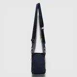 Bolso porta esenciales Bubba de diseño compacto y funcional, en color azul marino. Cuenta con un compartimento principal con cierre, bolsillo frontal adicional y correa ajustable con logo de la marca estampado.