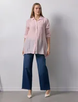 Camisa larga de rayón, con cuello clásico, cierre frontal con botones y mangas regulables con presilla. Presenta un diseño holgado con tajos laterales en el ruedo.