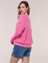Cardigan blanco de punto liviano y texturado, de corte holgado y diseño casual. Cuenta con escote en V pronunciado, abotonadura frontal, mangas largas con hombros caídos y bolsillos delanteros tipo parche.
