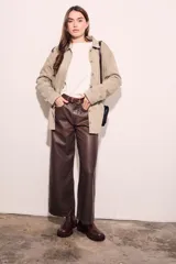 Sobrecamisa color beige de algodón peinado, corte recto, con cuello camisero, cierre frontal con botones y bolsillos de parche en el pecho.