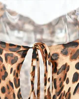 Vestido midi marrón con estampado animal print, breteles finos y escote drapeado.