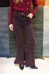 Jean de denim bordó con diseño de tiro alto, corte flare con botamanga acampanada y costuras frontales en relieve tipo alforza. Presenta efecto acid wash sutil.