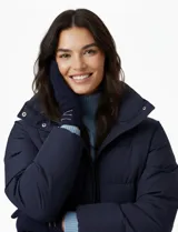 Guantes de mujer color beige claro, confeccionados en tejido soft (suede), con detalles de costuras cruzadas en color marrón en la muñeca.