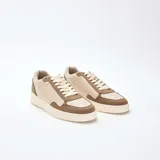 Zapatillas bajas de estilo retro, con paneles en color beige claro y marrón topo. Presentan cordones blancos y suela gruesa de color crema.