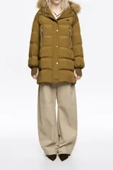 Campera puffer de largo medio en tejido técnico color verde oliva, con cierre frontal de cremallera y botones a presión. Cuenta con capucha con borde de pelo sintético desmontable, bolsillos laterales con cremallera y puños tejidos ajustados.