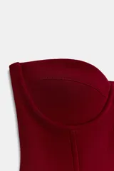 Corsé color bordó con aros y varillas, confeccionado en tejido elástico. Presenta escote corazón y diseño sin hombros.