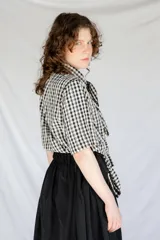 Camisa de algodón a cuadros gingham azul y blanco con estampado de broderie blanco, lazo en el cuello, manga corta y corte oversize.