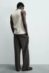 Pantalón de corte regular fit confeccionado en mezcla de algodón y lino. Presenta cintura elástica con cordón ajustable, cierre frontal con cremallera y botón, bolsillos laterales y bolsillo trasero de vivo con botón.