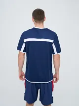 Remera deportiva de entrenamiento Umbro del Club Nacional de Football, color azul marino con detalles en blanco y líneas rojas en los hombros. Cuenta con el logo de la marca y el escudo del club en el pecho.