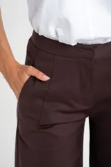 Pantalon de corte baggy y tiro medio, color marrón oscuro, con diseño de pierna ancha y bolsillos laterales.