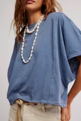 Remera de jersey de algodón blanca con silueta murciélago, escote barco y mangas dolman muy anchas de corte recto y holgado.