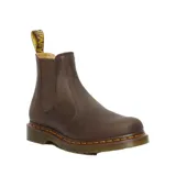 Botas Chelsea Dr. Martens modelo 2976, confeccionadas en cuero Crazy Horse color marrón con acabado envejecido. Presentan paneles elásticos laterales, suela de goma con costuras amarillas características y tirador trasero.