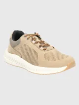 Zapatillas urbanas Hush Puppies con capellada de cuero perforado en tono beige, suela con tecnología Spinal de amortiguación y base de goma para mayor tracción.