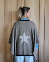 Ruana de tejido de punto en color crema con detalle de estrella grande en color verde lima en la espalda y bordes en tono arena.