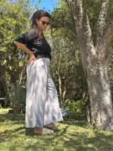 Conjunto compuesto por una blusa negra de corte holgado y mangas cortas, y un pantalón palazzo gris de tiro alto con faja ancha en la cintura y bolsillos laterales.