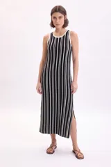 Vestido midi de punto sin mangas, con diseño a rayas verticales en color negro y blanco, escote redondo y tajo lateral en el bajo.
