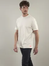 Remera color crema de algodón, con cuello redondo y mangas cortas. Estampado en la espalda con diseño de palmeras, tabla de surf y la palabra 'Mallorca'.