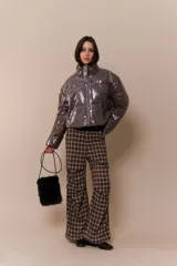 Campera puffer color marrón con cuello alto, cierre frontal con cremallera y bolsillos laterales.