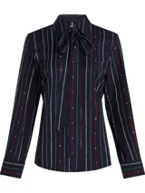 Camisa de manga larga azul marino con rayas verticales rojas y blancas, con lazo extraíble en el cuello.
