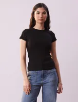 Remera negra de tejido acanalado, marca Cyrus, con escote a la base y manga corta.