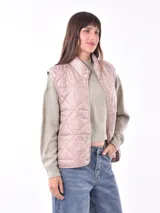 Chaleco acolchado color rosado con diseño de rombos, cuello alto y cierre frontal con botones a presión metálicos.