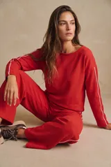 Sweater oversize rojo de algodón peinado, con mangas largas y una línea blanca decorativa a lo largo de cada manga.