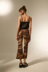 Pantalon jean de corte flare y tiro alto con estampado camuflado en tonos marrones.