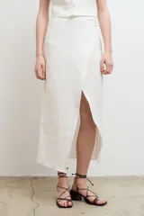Falda midi de lino con diseño cruzado y tajo frontal.