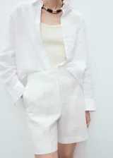 Short de lino color blanco, de tiro medio y diseño recto con bolsillos laterales.