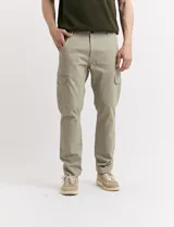 Pantalón de gabardina color marrón, corte slim fit, con bolsillos laterales tipo cargo.