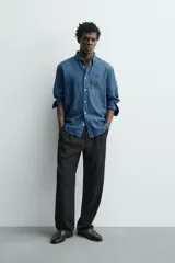 Camisa regular fit de denim de algodón azul, con cuello solapa, manga larga con puños abotonados, un bolsillo de parche en el pecho y cierre frontal de botonadura.