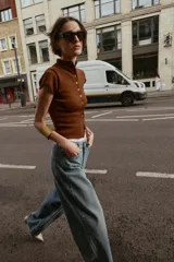 Top de tejido de punto color marrón óxido, manga corta y cuello mao con cierre frontal de botones.