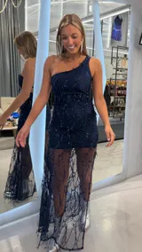 Vestido largo azul marino de un hombro, con apliques de lentejuelas y diseño de transparencias en la falda.