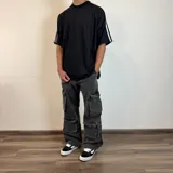 Pantalón de jean estilo cargo con corte baggy, color azul lavado. Presenta cuatro bolsillos laterales de gran tamaño con solapa y cierre de botones, diseño de pierna ancha y tiro medio.
