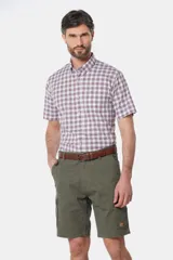 Bermuda cargo color beige con bolsillos laterales y traseros. Se ajusta a la cintura con cinturón de cuero marrón.