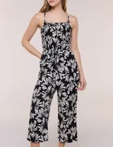 Enterito crop de rayón con estampado geométrico en blanco y negro, busto elastizado con frunces, breteles finos regulables y cordón ajustable en la cintura con terminaciones de borlas. Pantalón de corte amplio y relajado.
