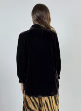 Camisa verde oscuro de terciopelo de viscosa, con cuello mao, corte recto, mangas largas abullonadas y cierre frontal con botones.