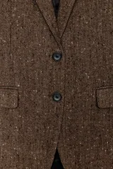 Blazer de Zara confeccionado en hilatura con lana, con diseño de espiga en tonos marrones. Presenta cuello solapa, manga larga con botones, bolsillo de vivo en el pecho y bolsillos delanteros con solapa. Cierre frontal con botones y forro interior negro.