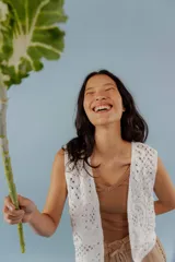 Chaleco negro de tejido de punto abierto, sin mangas y sin cierre, con cuello solapa.