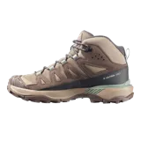 Calzado de trekking Salomon modelo X Ultra 360 Leather Mid Gore-Tex, de corte alto, color marrón y tostado con detalles en verde. Confeccionado con cuero resistente, malla y membrana impermeable Gore-Tex.