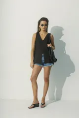 Blusa blanca sin mangas con escote en V y abertura frontal.